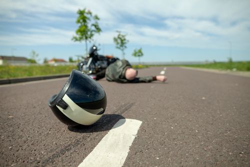 Motorradfahrer und Helm nach Unfall auf der Straße