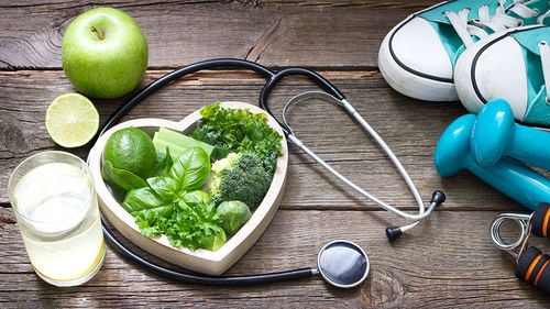 Grünes Obst und Gemüse, Sportgeräte und Stethoskop, Symbolbild