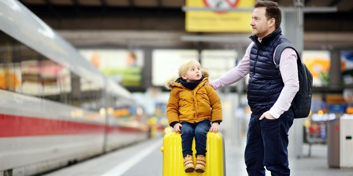 Vater und Kind warten am Bahnhof auf Abreise