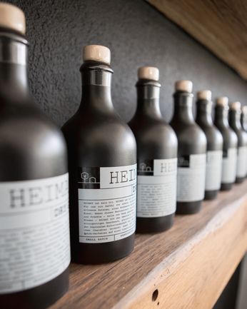Mehrere Flaschen Heimat Dry Gin nebeneinander auf einem Regal