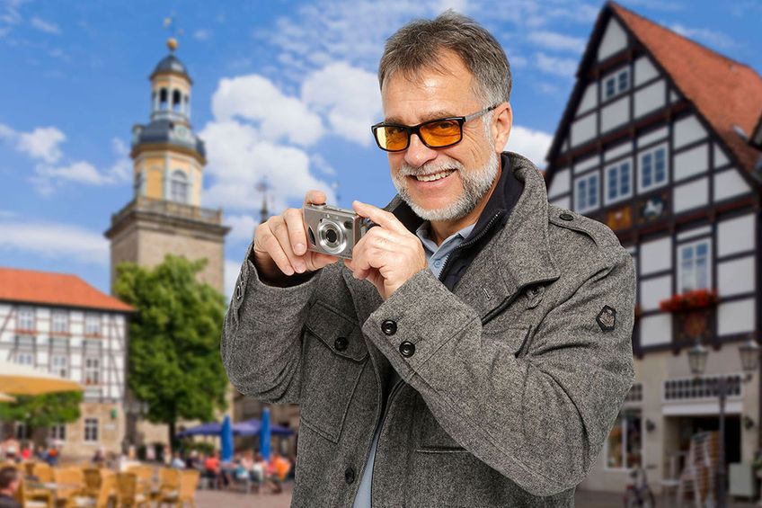 Mann mit Spezialbrille macht Fotos in einer Altstadt