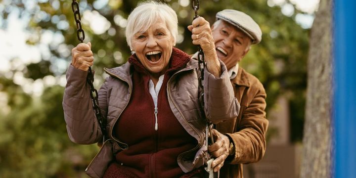 Lachendes Seniorenpaar mit Schaukel