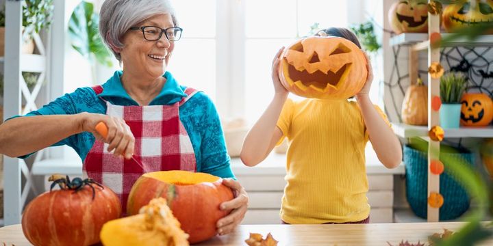 Oma und Enkel schnitzen Kürbisse zu Halloween