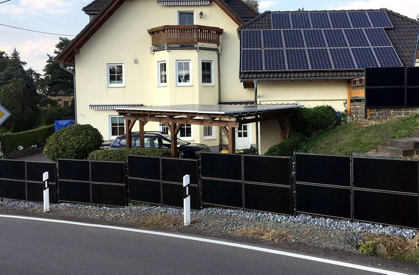 Solarzaun vor einem Wohnhaus