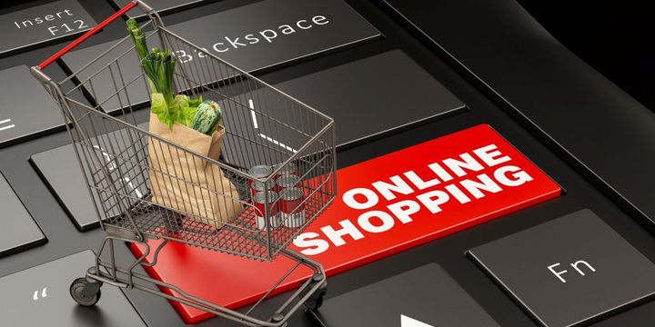 PC-Tastatur mit Mini-Einkaufswagen und Symbol Online-Shopping