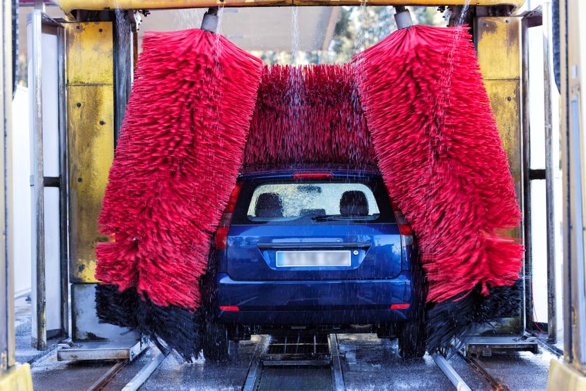 Auto in der Waschanlage mit roten Bürsten
