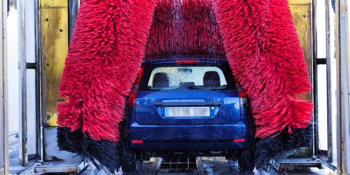 Auto in der Waschanlage mit roten Bürsten