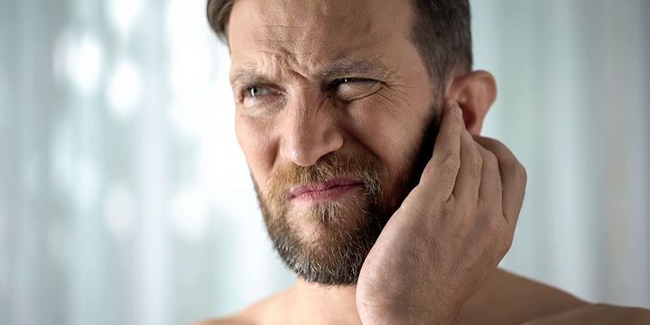 Mann hat Schmerzen im Ohr- und Kieferbereich