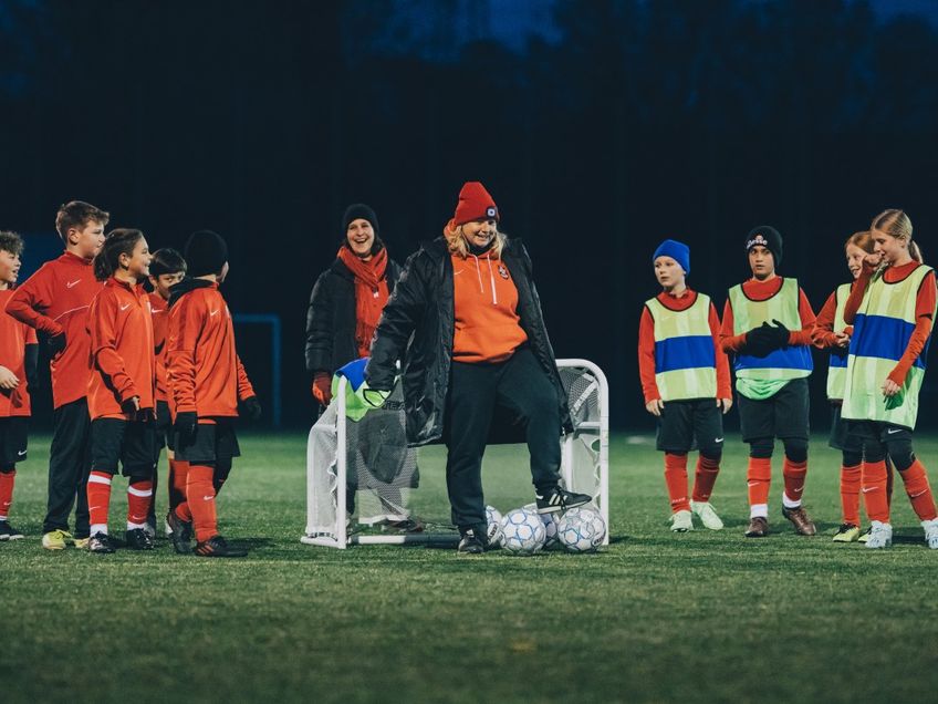 Zwei Trainerinnern mit neun Kindern beim Fußballtraining