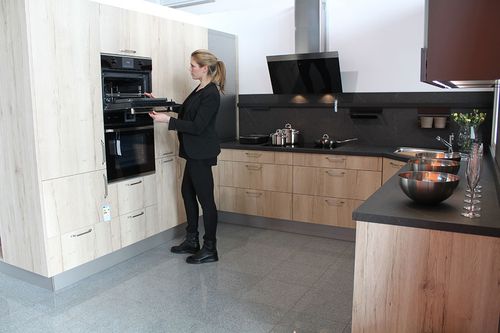 Küche in Holzdekor mit schwarzen Elementen beim Küchenstudio Röck Ilsfeld