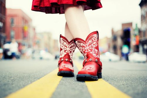 Trendy Schuhmode mit roten Western-Stiefeln und rotem Rock