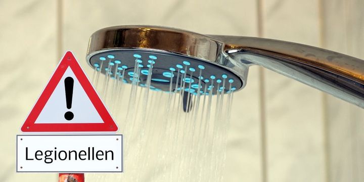 Legionellen-Warnschild in laufender Dusche