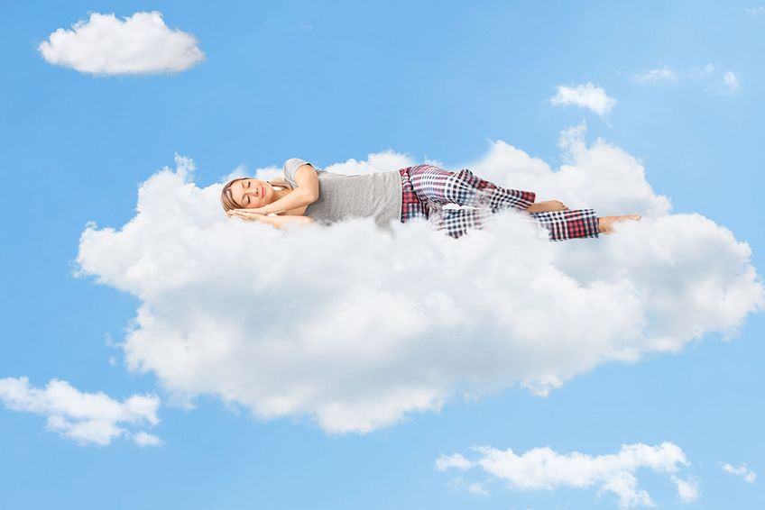 Frau schläft auf einer Wolke