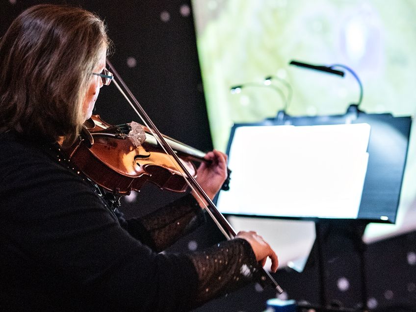 Die Musikerin Caroline Korn spielt Violine, es liegen Noten auf einem Notenständer
