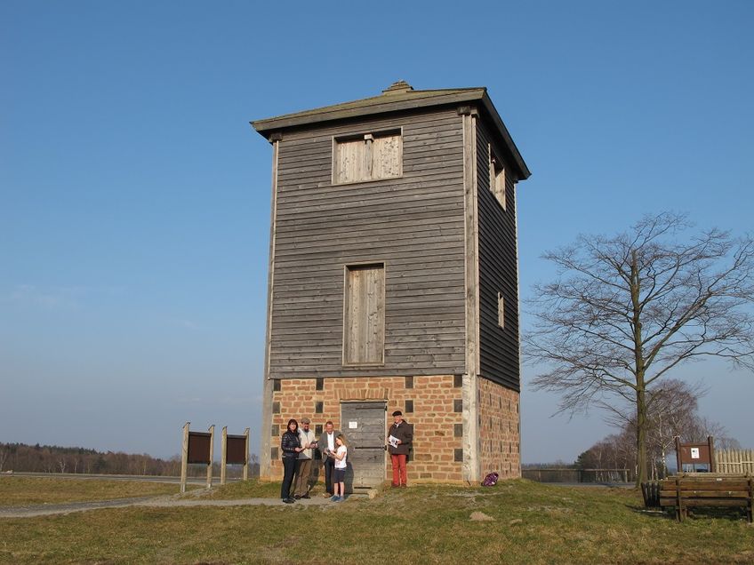 Eine Gesamtansicht des Limeswachturms in Michelstadt mit Besucher*innen im Vordergrund.