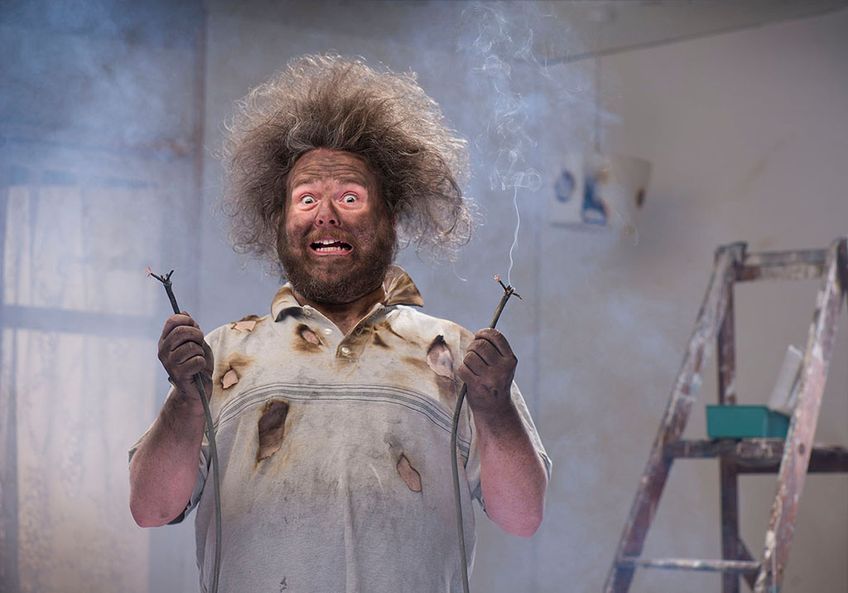 Mann hat sich bei Elektroinstallation verbrannt - humoristische Darstellung