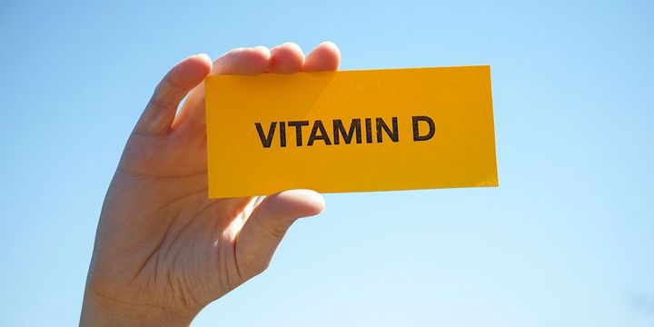Hand mit Schild, auf dem "Vitamin D" steht