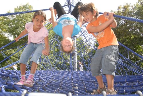 Kinder klettern auf dem Riesenkletternetz im Herzogenriedpark Mannheim