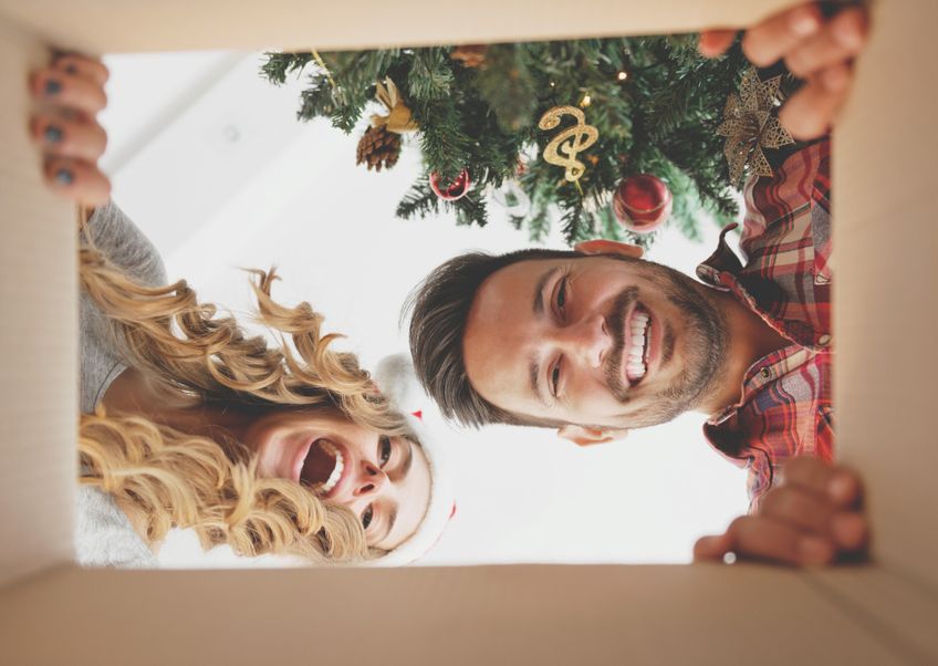 Paar öffnet Weihnachtsgeschenk von der Perspektive des Geschenks