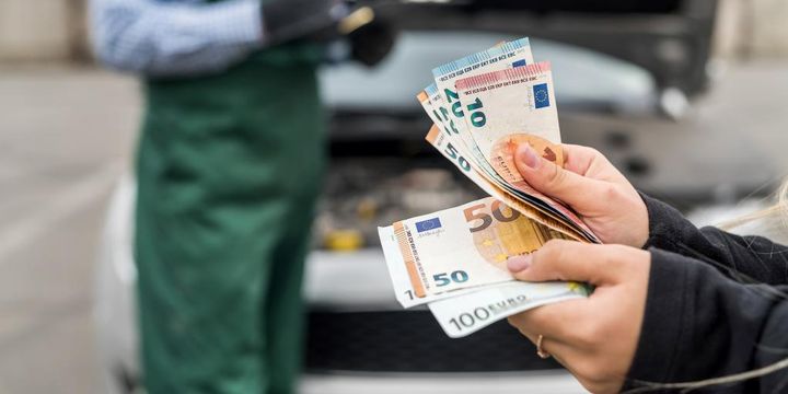 Autowerkstatt und Geldscheine in Kundenhänden