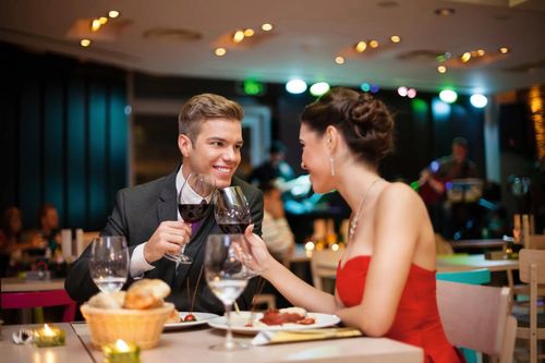 Paar im Restaurant stößt mit Rotwein an