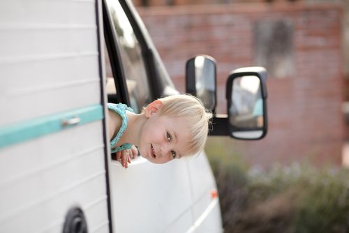 Kind schaut aus dem Seitenfenster des Reisemobils