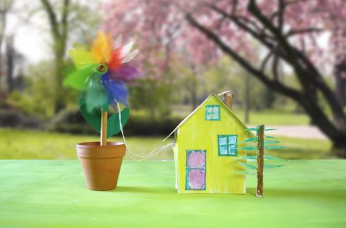 Symbolbild Windenergie für zu Hause: Windrädchen neben Einfamilienhaus