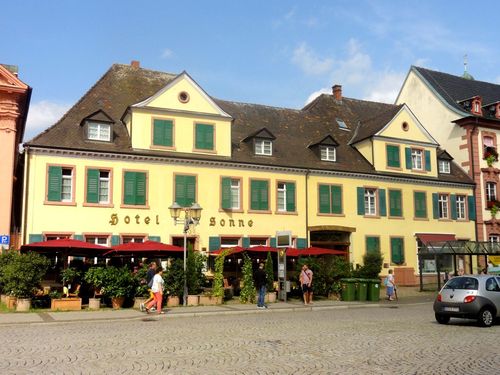 Das Offenburger Hotel Sonne mit gelber Fassade und grünen Fensterläden