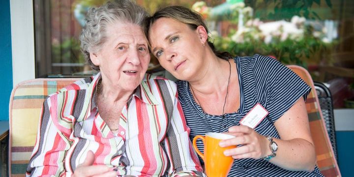 Seniorin mit Pflegerin im vertrauten Gespräch