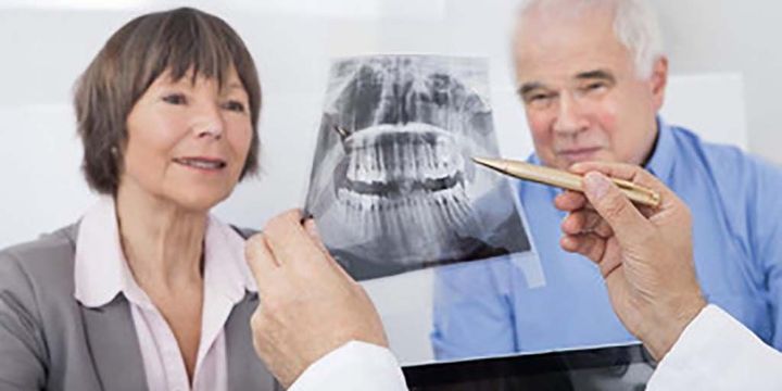 Älteres Paar lässt sich beim Zahnarzt ein Röntgenbild zeigen