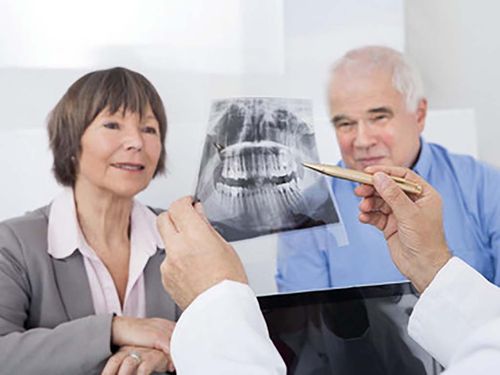 Älteres Paar lässt sich beim Zahnarzt ein Röntgenbild zeigen