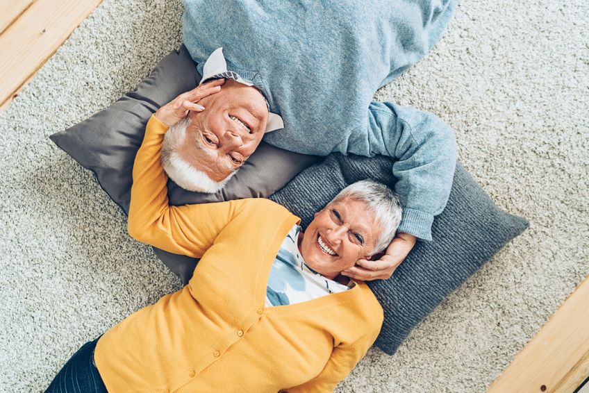 Glückliches Seniorenpaar zuhause liegend