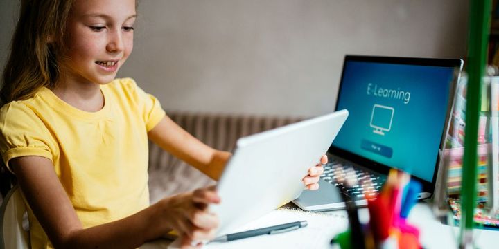Mädchen mit Tablet und Laptop beim E-Learning