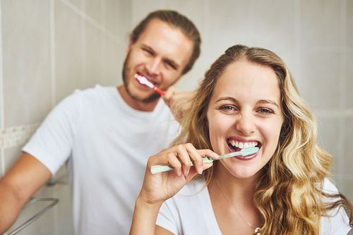 Mann und Frau putzen sich die Zähne