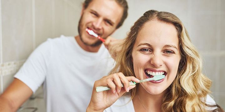 Mann und Frau putzen sich die Zähne