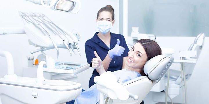 Patientin und Zahnärztin zeigen "Daumen hoch"