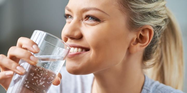 Frau trinkt Mineralwasser