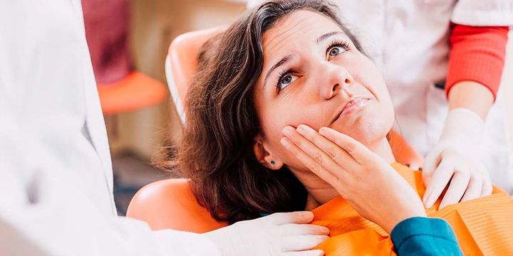 Frau beim Zahnarzt mit Zahnschmerzen