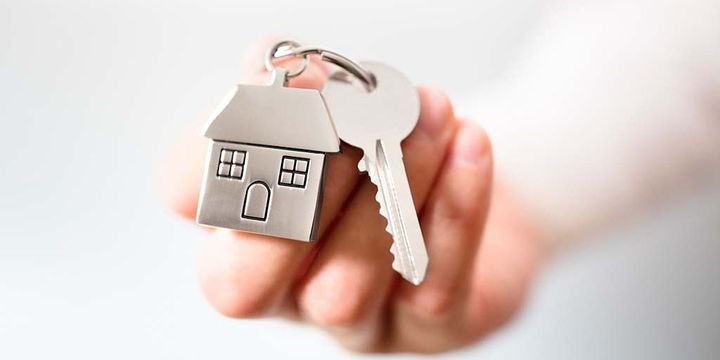 Schlüssel mit Schlüsselanhänger in Haus-Form symbolisiert Schlüsselübergabe