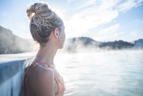 Frau befindet sich im Thermalbad und blickt auf Wasser