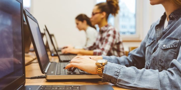 Junge Frauen mit Laptops im Klassenzimmer