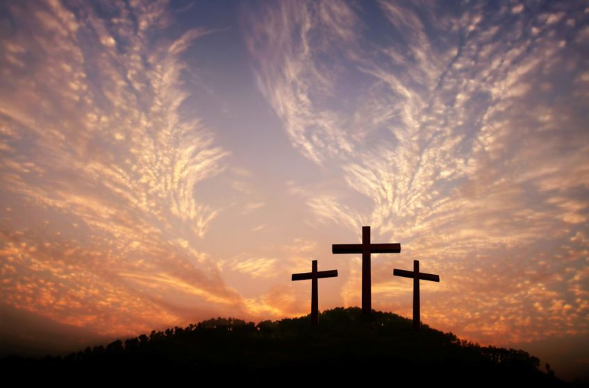 Drei Kreuze auf einem Hügel im Sonnenuntergang - Symbol für Ostern