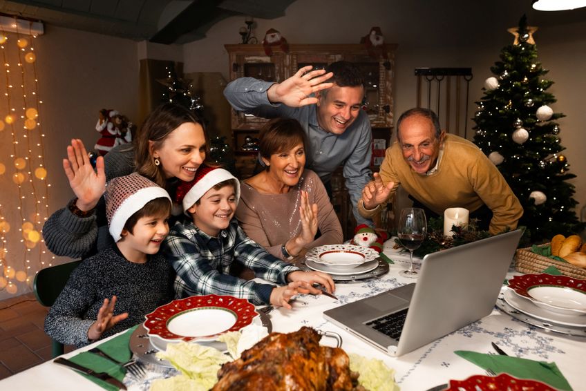 Familie winkt beim Videogruß zu Weihnachten in die Laptop-Kamera