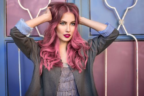Frau mit ungewöhnlicher, rosa-roter Haarfarbe