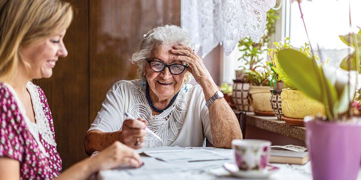 Jüngere Frau verbringt Zeit mit einer Seniorin an einem schönen Nachmittag