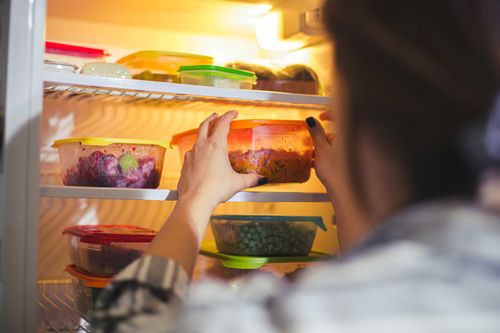 Meal Prep: Vorbereitetes Essen in Dosen in den Kühlschrank stellen