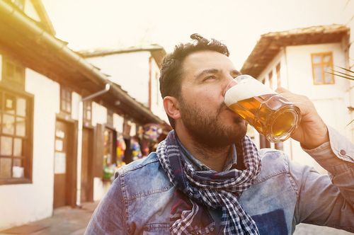 Mann genießt ein Bier unter freiem Himmel